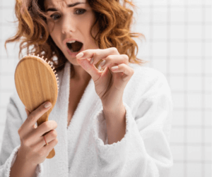 Haarausfall zeigt eine Frau die sich kämmt und Haarausfall bemerkt